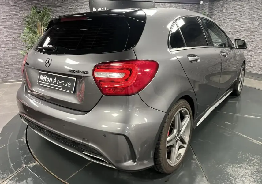 Vue 3/4 arrière droite d'une Mercedes Classe A 45 AMG grise avec jantes AMG et étriers de frein rouges visibles.