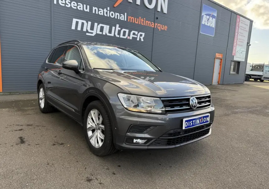 Volkswagen Tiguan gris Indium en 3/4 avant droit, avec jantes alliage 18 pouces et projecteurs antibrouillard.