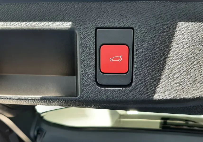 Bouton rouge de fermeture électrique du hayon sur le bord intérieur du coffre du Citroën C5 Aircross vert Astoria.