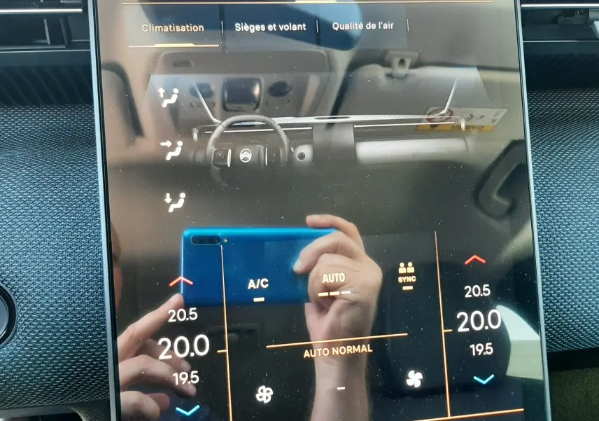 Écran tactile central du Citroën C5 Aircross 2026 affichant les réglages de climatisation avec interface moderne et reflet du conducteur.