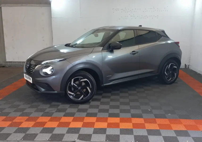 Nissan Juke Hybrid 143 Business+ gris foncé, vue 3/4 avant droit, jantes noires à motifs argentés.