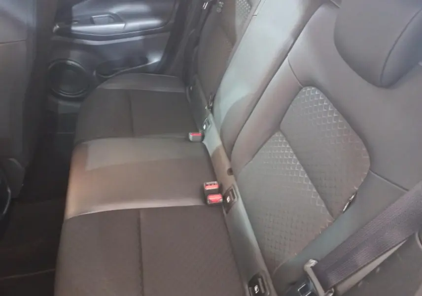 Vue intérieure du siège arrière droit du Nissan Juke Hybrid 143 Business+ 2023, tissu gris foncé avec ceinture de sécurité.