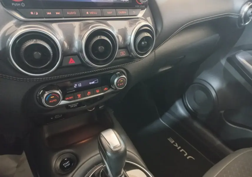 Vue intérieure côté passager du tableau de bord et console centrale noire du Nissan Juke Hybrid 143 Business+ 2023.