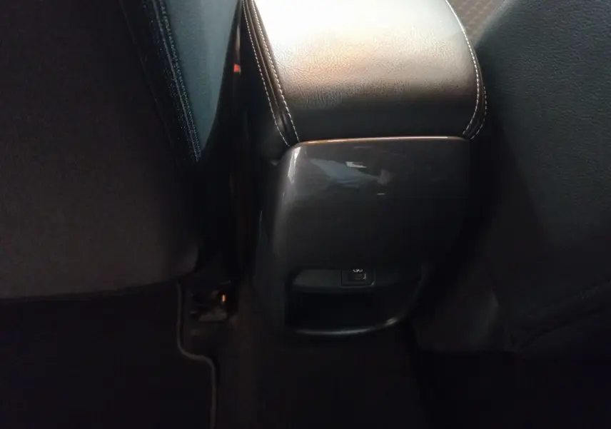 Vue rapprochée de la console centrale arrière en cuir noir avec port USB du Nissan Juke Hybrid 2023 gris foncé.