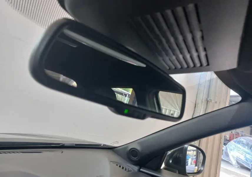 Intérieur du Nissan Juke Hybrid 143 Business+ 2023, vue du rétroviseur intérieur et du côté droit gris foncé visible à l'extérieur.