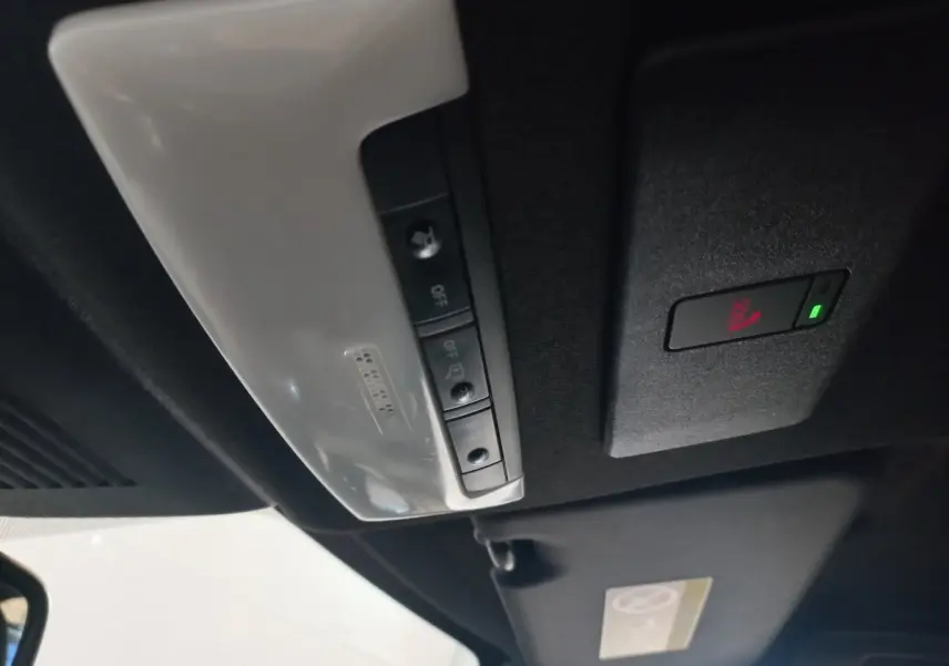 Vue intérieure du plafond avec commandes d'éclairage et bouton SOS du Nissan Juke Hybrid 143 Business+ gris foncé 2023.