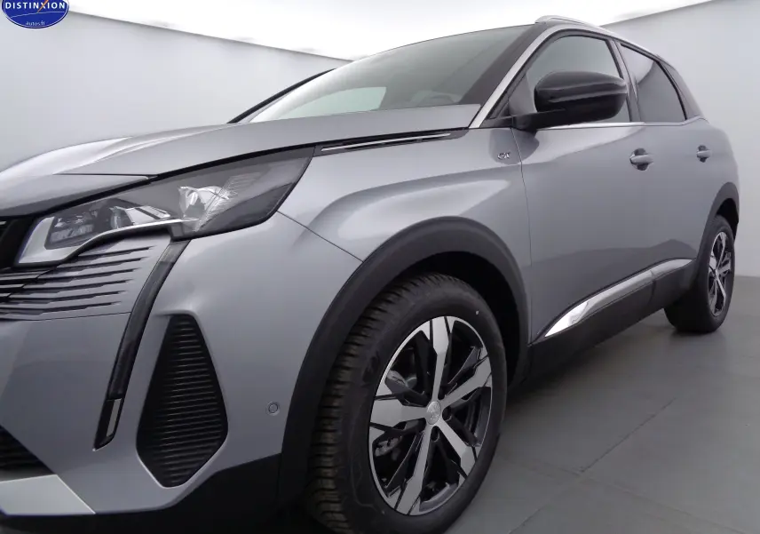 Peugeot 3008 gris Artense métal en vue 3/4 avant droit, avec jantes alliage et badge GT sur aile avant.
