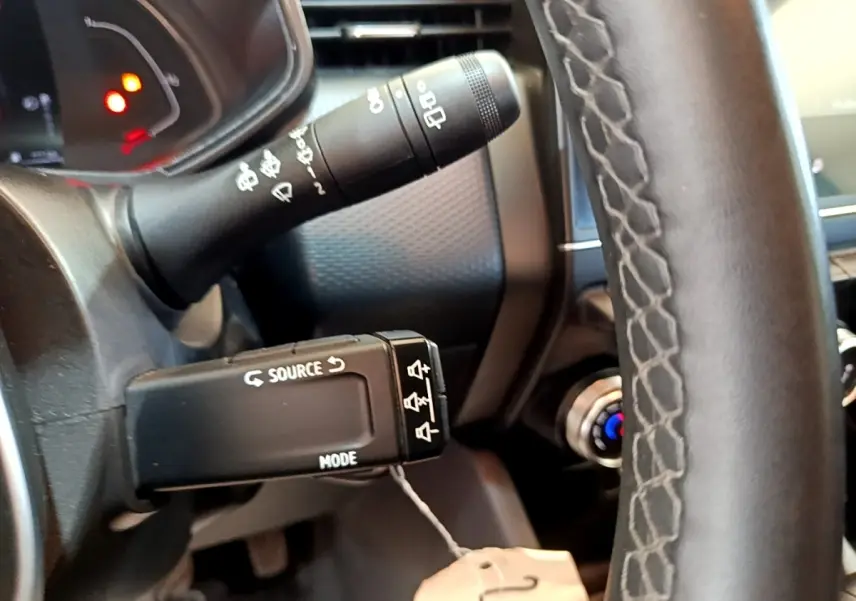 Gros plan sur la commande multifonctions à gauche du volant en cuir noir du Renault Clio Business E-Tech hybride 2021.