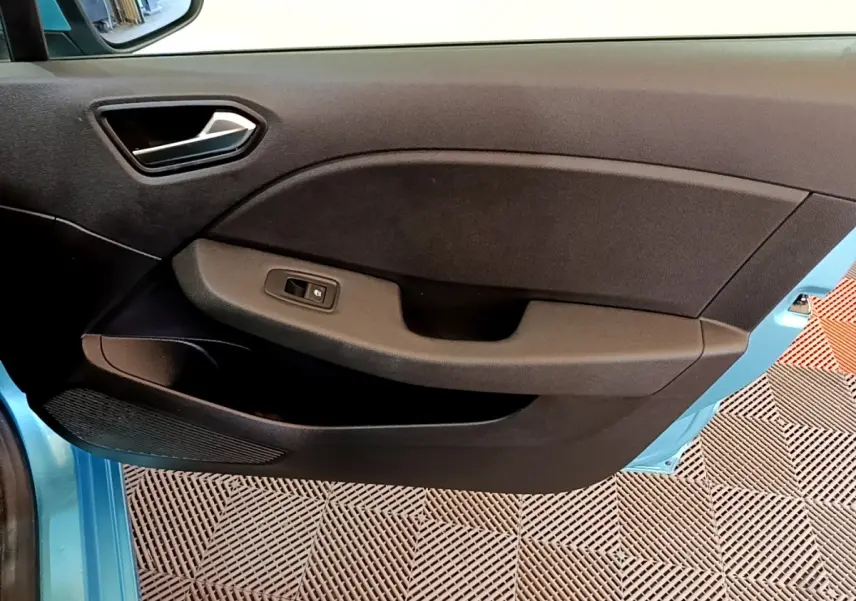 Vue rapprochée de la porte avant gauche bleu clair de la Renault Clio Business E-Tech hybride 2021 avec commande de vitre électrique.