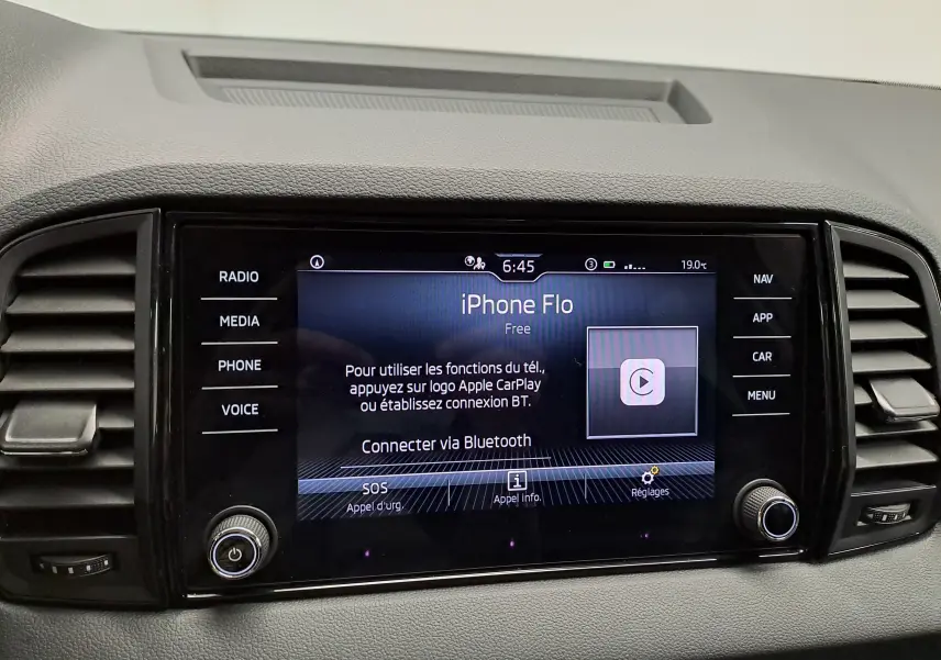 Écran tactile central du Skoda Karoq 1.5 TSI blanc, affichant la connexion Bluetooth et les commandes multimédia.