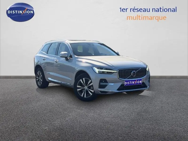 Vue 3/4 avant d'un Volvo XC60 gris métallisé avec calandre chromée et jantes alliage, sur fond neutre.