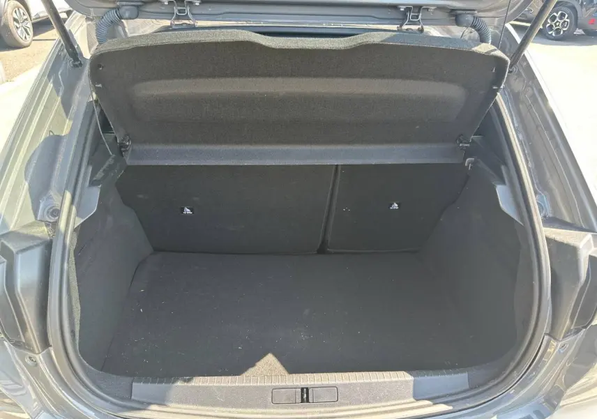 Coffre ouvert d’une Peugeot 208 gris Selenium 2025, vue plongeante sur l’espace de chargement vide.