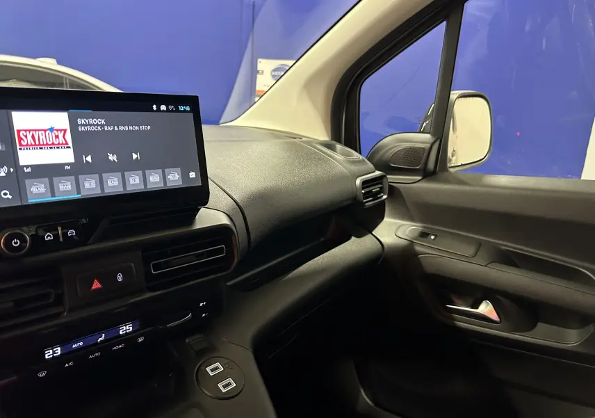 Intérieur côté passager du Citroën Berlingo Multispace gris, avec tableau de bord moderne et écran tactile allumé.