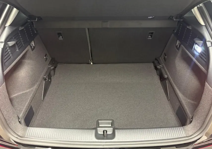 Coffre ouvert vu de l'arrière d'un Audi Q2 35 TFSI S Line noir Mythic, montrant un espace de chargement propre et éclairé.