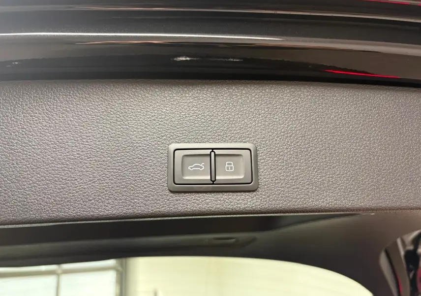 Boutons de commande du hayon électrique sur la partie intérieure du coffre d'un Audi Q2 Noir Mythic 2026.