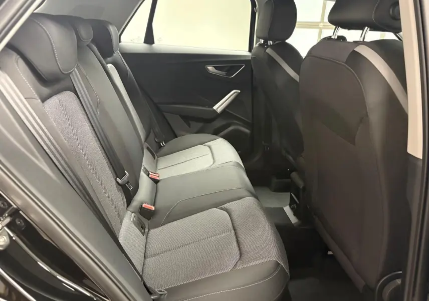 Vue intérieure côté droit des sièges arrière en tissu gris et noir de l’Audi Q2 35 TFSI S Line 2026 Noir Mythic.