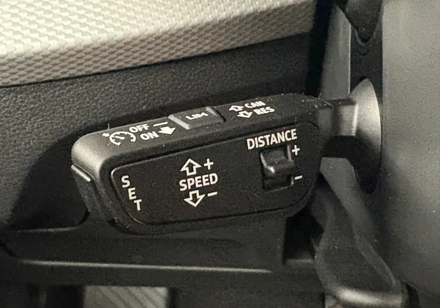 Gros plan sur le levier de commande du régulateur de vitesse d’un Audi Q2 35 TFSI S line, intérieur noir.