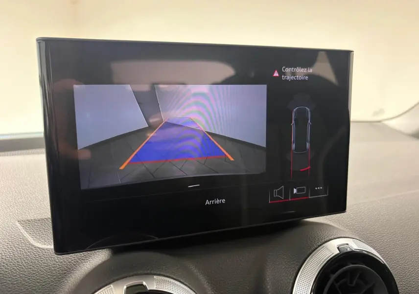 Écran central montrant la caméra de recul et l'alerte de trajectoire dans l'Audi Q2 35 TFSI Noir Mythic.