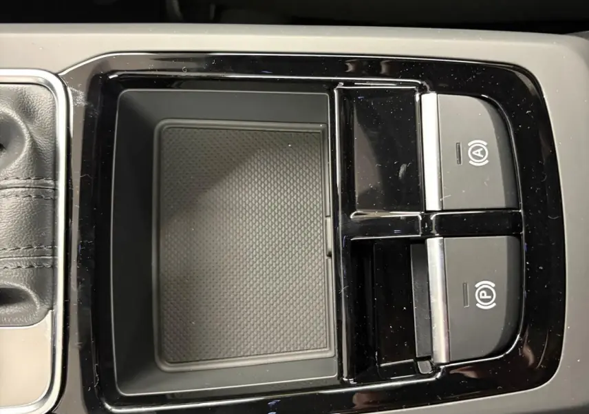 Gros plan sur la console centrale noire avec commandes de frein à main électronique dans l'Audi Q2 Noir Mythic 2026.