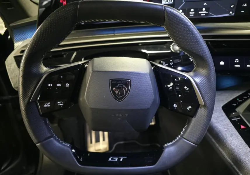 Volant cuir noir GT de Peugeot 3008 2025, vue de face avec commandes intégrées et logo central lion.