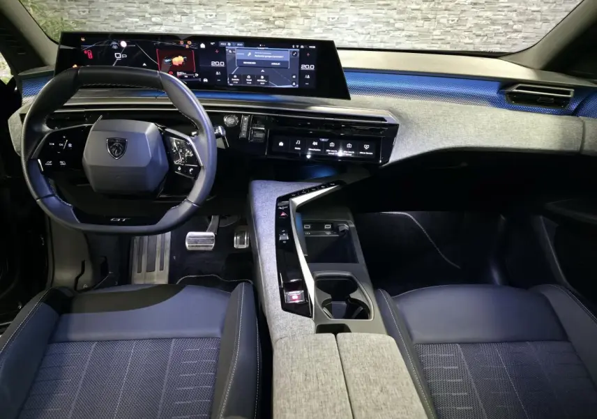Vue intérieure avant du Peugeot 3008 2025 noir, tableau de bord avec écran panoramique et volant compact GT.