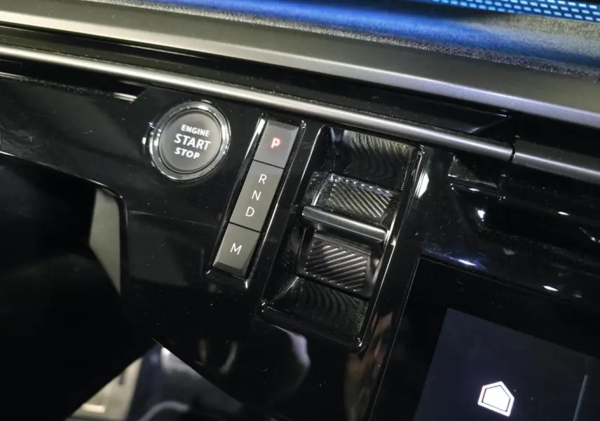 Détail de la console centrale noire brillante du Peugeot 3008 2025 avec bouton start/stop et commandes de boîte automatique.