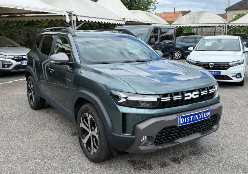 SUV Dacia Duster Hybrid 140 Journey vert cèdre en 3/4 avant avec calandre noire distinctive et jantes noires et argentées.