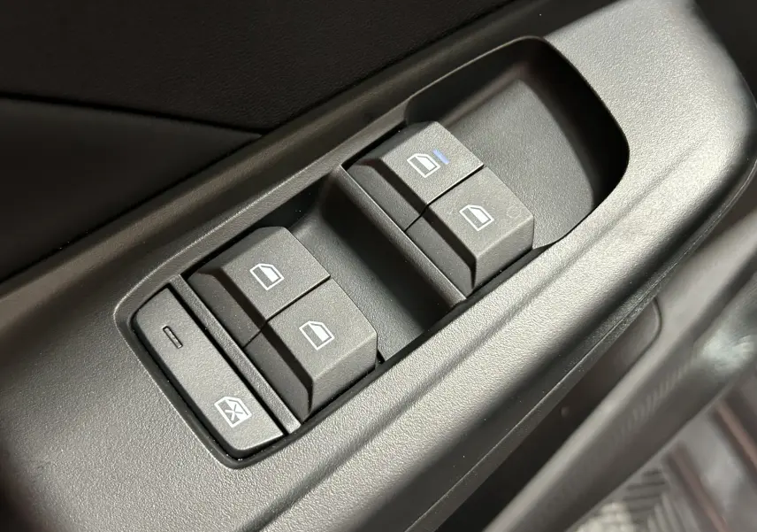 Gros plan sur les commandes des vitres électriques côté conducteur de la MG3 1.5 Hybrid+ Pebble Black, intérieur noir.