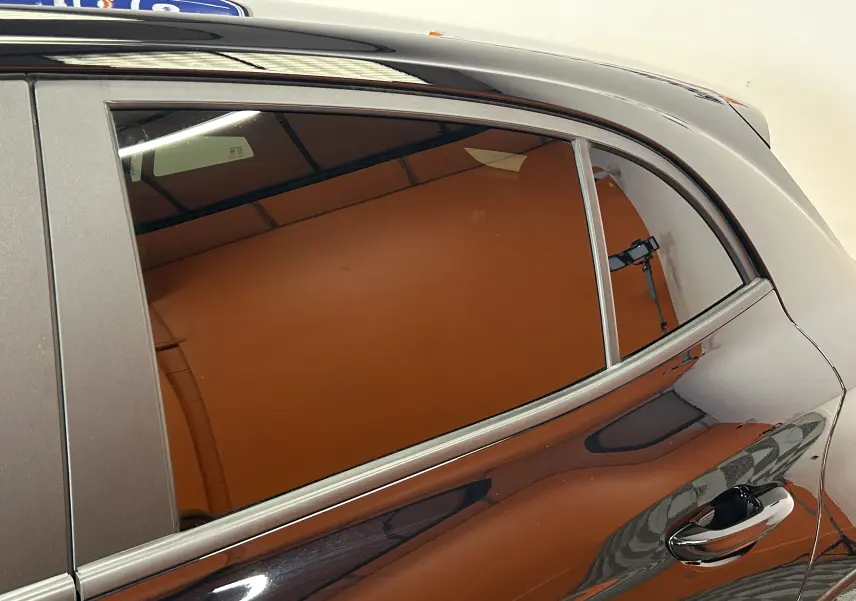 Gros plan sur la porte arrière côté droit du MG3 Hybrid+ 195 Luxury Pebble Black avec reflet et poignée chromée visible.
