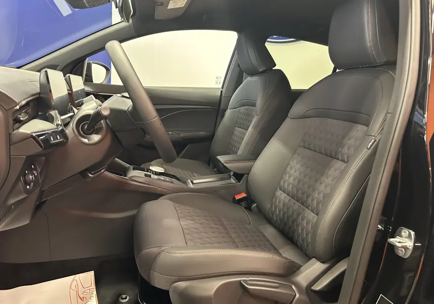 Vue intérieure côté conducteur de la MG3 Hybrid+ 195 Luxury noire, sièges en tissu et cuir avec surpiqûres contrastées.