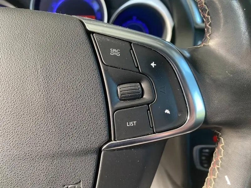 Gros plan sur les commandes du volant côté gauche de la DS4 gris Platinium, avec molette et boutons fonctionnels.