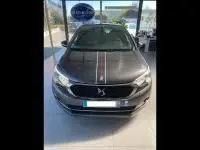 Vue de face d'une DS4 gris Platinium 2017 avec bande centrale noire et rouge, dans un showroom lumineux.