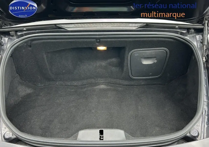 Coffre arrière ouvert d'une Porsche Boxster 987 noir, montrant l'espace de rangement intérieur et la lumière intégrée.