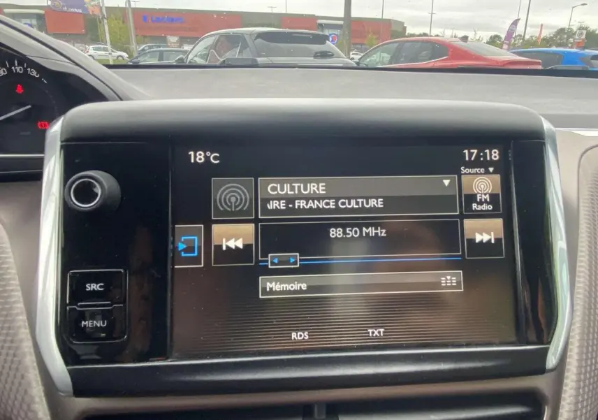 Écran tactile central du Peugeot 2008 blanc de 2015 affichant la radio FM sur France Culture à 88,5 MHz, vue intérieure frontale.