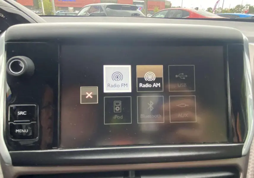 Vue intérieure du tableau de bord du Peugeot 2008 blanc de 2015, écran tactile affichant options Radio FM et AM.