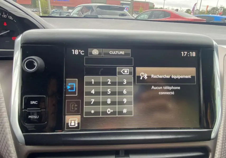 Vue intérieure du tableau de bord du Peugeot 2008 blanc 2015, avec écran tactile affichant le menu téléphone.