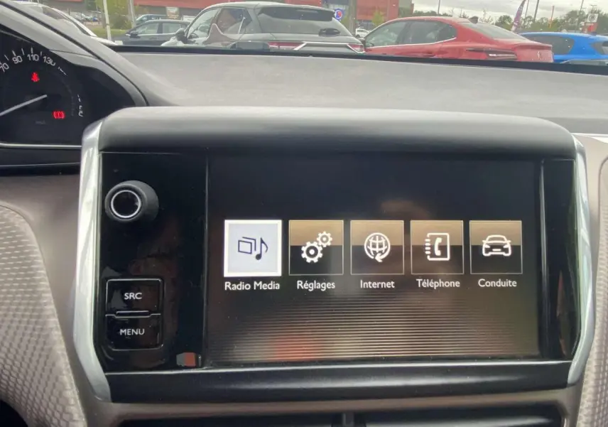 Écran tactile central du tableau de bord du Peugeot 2008 blanc de 2015, affichant les options Radio, Réglages, Internet, Téléphone et Conduite.