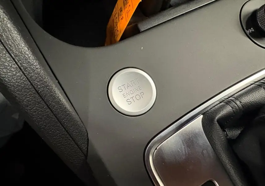 Bouton Start/Stop moteur en gros plan sur la console centrale noire de l'Audi Q2 35 TFSI S Line 2026.
