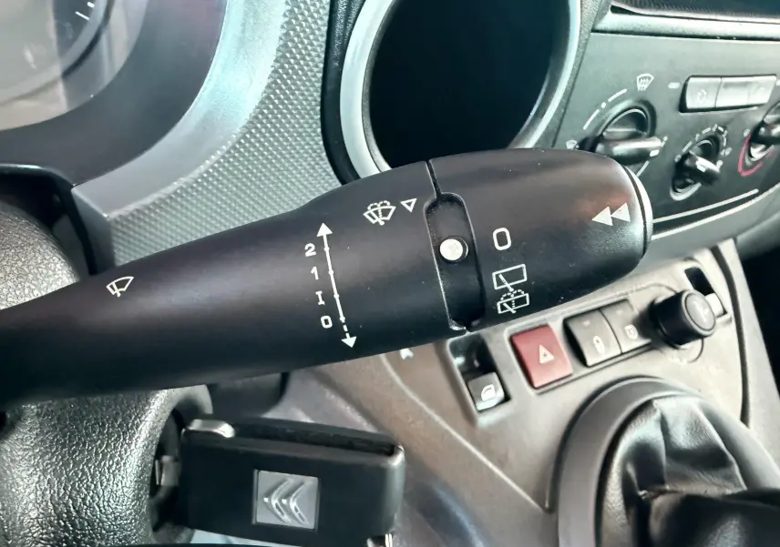 Gros plan sur la commande d’essuie-glace et la clé de contact du Citroën Berlingo 1.6 HDI blanc, intérieur tableau de bord.