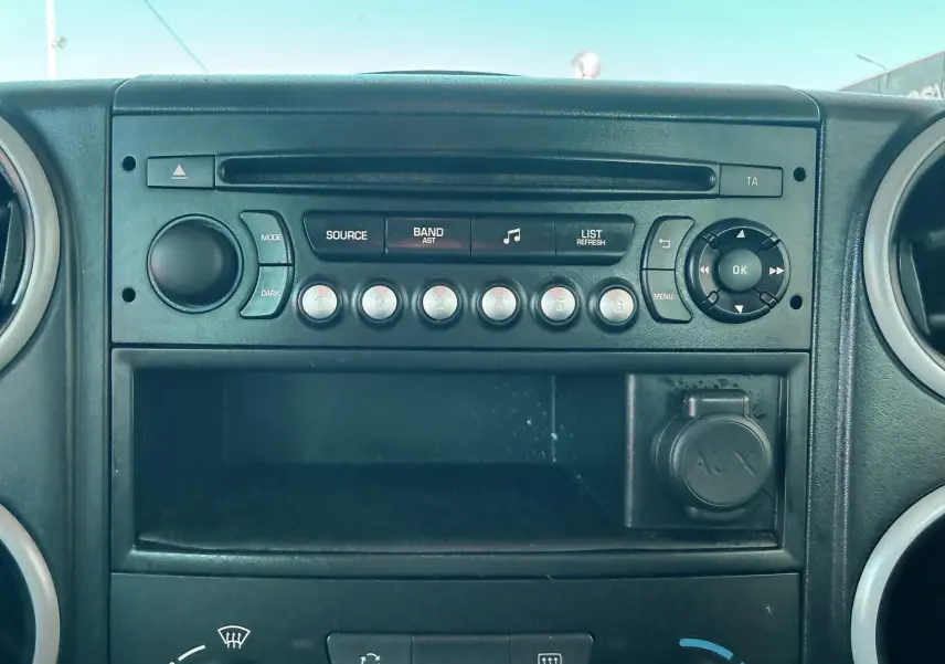 Vue rapprochée du tableau de bord noir du Citroën Berlingo 2017, montrant la radio et les commandes centrales.