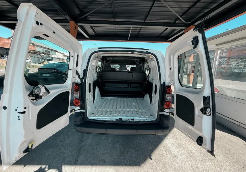 Vue arrière du Citroën Berlingo blanc 2017 avec portes ouvertes montrant l’espace de chargement vide et la cloison de séparation.