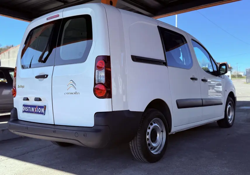 Vue 3/4 arrière droite d’un Citroën Berlingo blanc utilitaire avec portes arrière vitrées et protections noires.