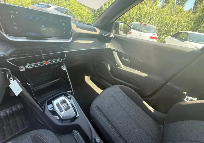 Intérieur avant droit du Peugeot 2008 Hybrid 136 e-DCS6 Style 2025 noir, avec écran tactile et console centrale brillante.