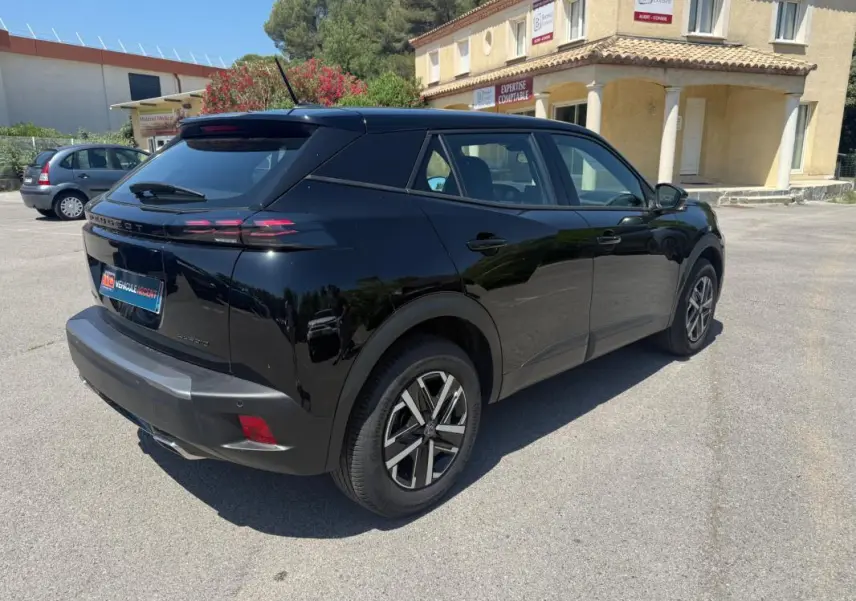 Peugeot 2008 Hybrid 136 e-DCS6 Style noir vue 3/4 arrière droit, jantes 16 pouces et feux arrière LED distinctifs.