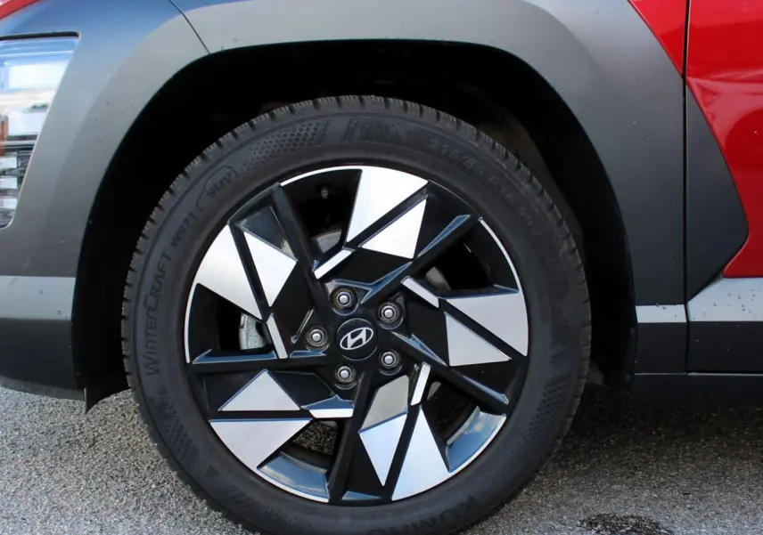 Gros plan sur la roue avant droite du Hyundai Kona rouge Ultimate Metal avec jante alliage noire et argentée.