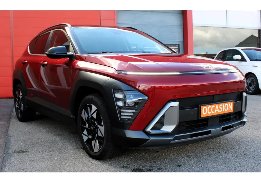 Hyundai Kona 2024 rouge Ultimate Metal avec toit noir, vue 3/4 avant mettant en valeur ses feux LED et jantes alliage.