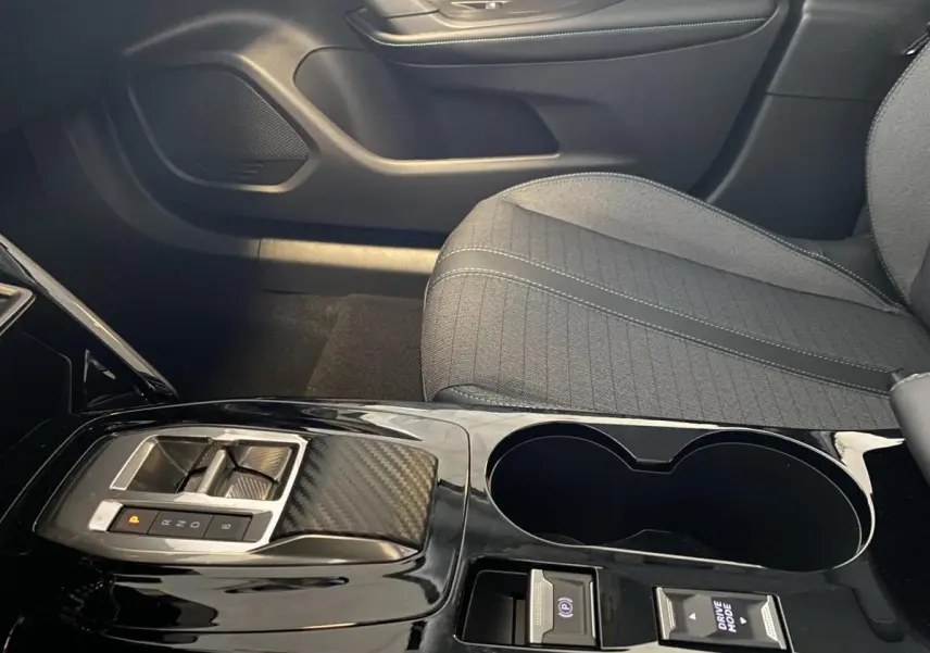 Vue rapprochée de la console centrale noire brillante et siège tissu gris du Peugeot 2008 e-136 Allure Pack 2022.
