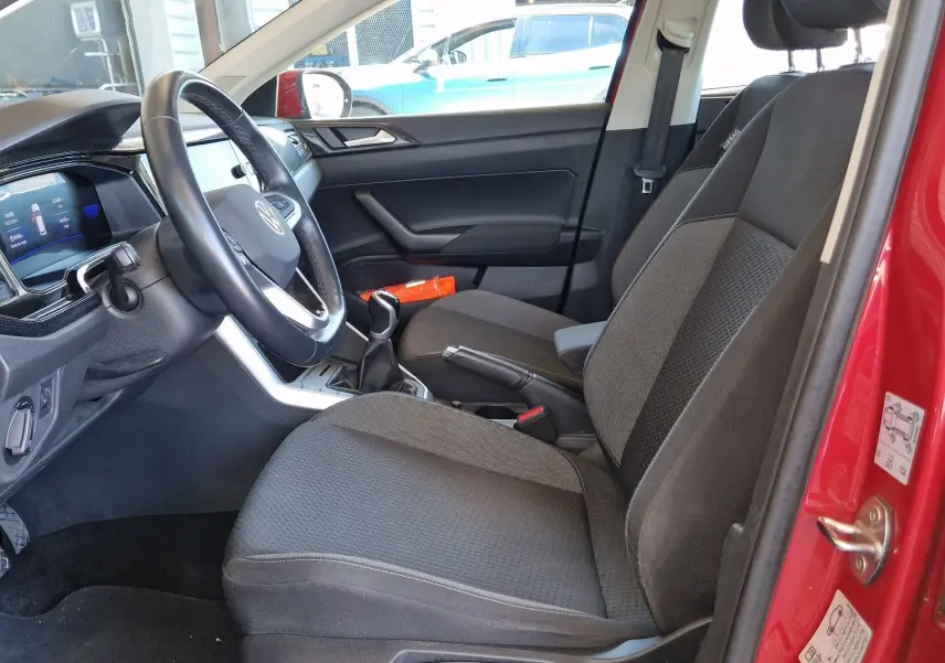 Vue intérieure côté conducteur du Volkswagen Taigo rouge roi 2023, montrant les sièges et le tableau de bord moderne.