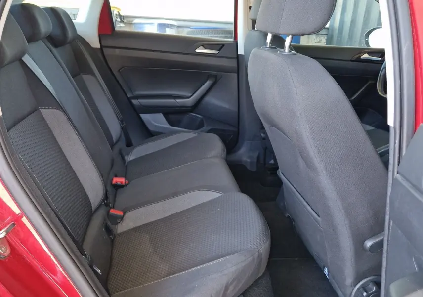Vue intérieure côté gauche des sièges arrière en tissu gris d'un Volkswagen Taigo rouge roi 2023, porte ouverte.