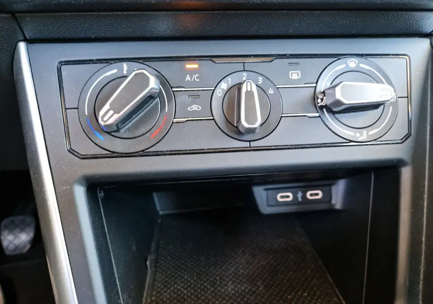 Gros plan sur les commandes de climatisation manuelle et prises USB du Volkswagen Taigo 2023, intérieur noir.